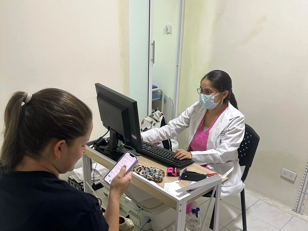 Profesional de salud atendiendo a una paciente durante consulta médica